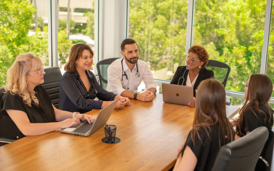 Several individuals collaborating and sharing ideas while seated at a conference table in a professional setting.